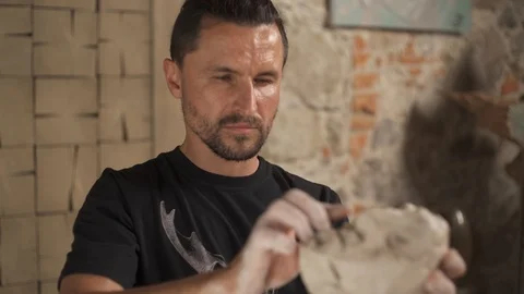 Sculptor modelling sculpture adjusting face details. Male head made of clay. Stock Footage 113108012