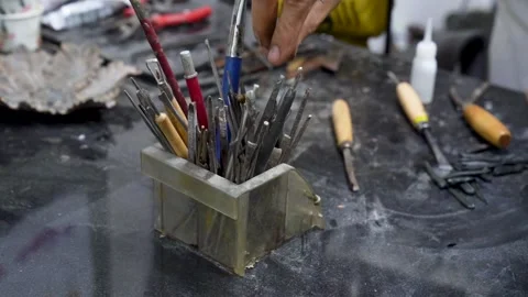 A sculptor or artisan picking tools from the tool box. A man using traditio.. Stock Footage 244741376