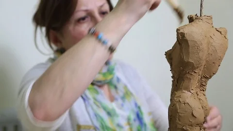 A sculptor working on a statue and shaping it with modeling pen Stock Footage 72099074