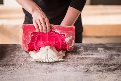 The sculptor works in a plaster workshop. Separates the silicone mold from the Stock Photos
