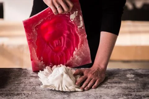 The sculptor works in a plaster workshop. Separates the silicone mold from the Stock Photos