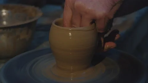 A sculptor in a workshop makes a clay jug close up. Man's hand making a clay jug Stock Footage 130197036