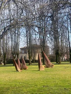 Sculptural elements emerging from green grass in a public park, contrasting.. Stock Photos