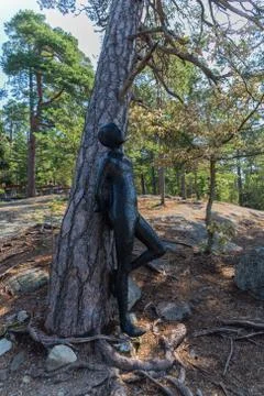 Sculpture of a boy by a tree Stock Photos