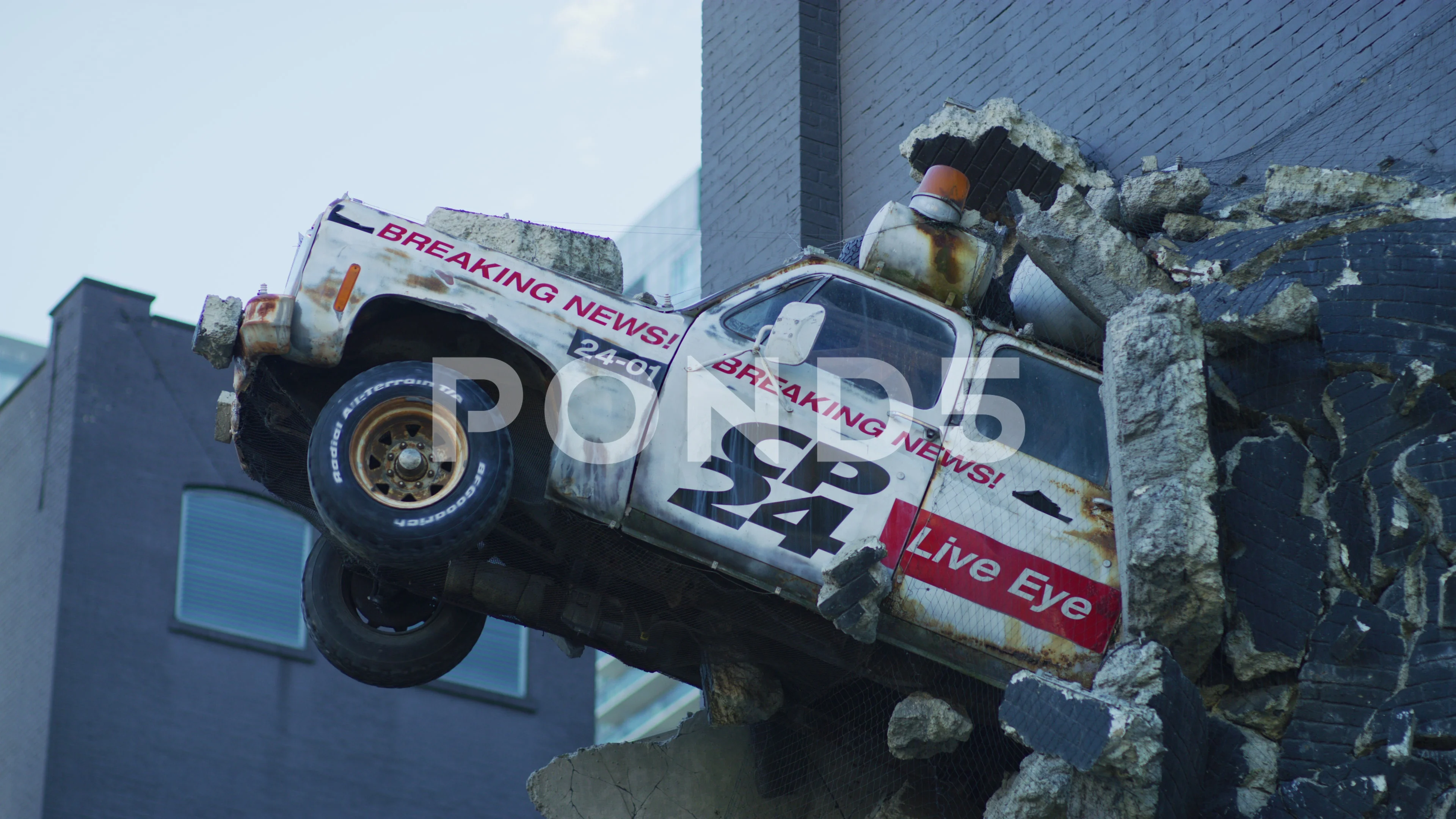 Sculpture of news truck breaking out of , Stock Video