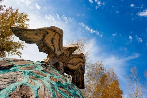 Sculpture of a soaring eagle on a background of bright sky Stock Photos
