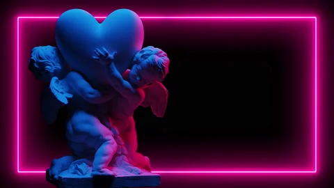 Sculpture Of Two Cupids Hold A Big Heart In Neon light On A Dark Background Video stock 122438484