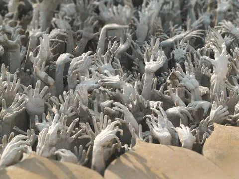 Sculptures of reaching hands from hell at Wat Rong Khun White Temple in Chi.. Stock Photos