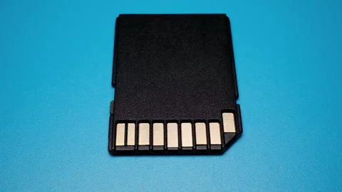 SD Card Metal Contacts Data Electronics Illumination Front View on Blue Video Stock Footage 344776445