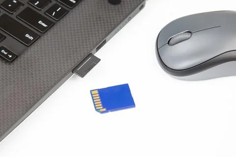 Sd memory card for recording electronic data near a laptop on a white backg.. Stock Photos