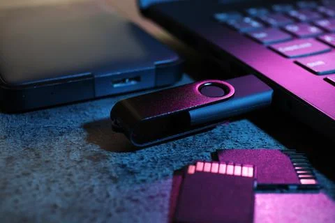SD memory cards, USB flash drive, hard disk drive and laptop on dark grey t.. Stock Photos