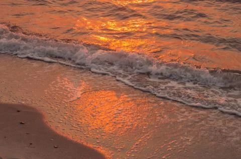 Sea and sand with reflection of the sunset Stock Photos