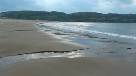 Sea and sandy beach on the background of low rocky mountains. Stock Footage 73464856