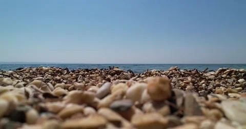 Sea and waves from behind the pebbles. 4K Stock Footage 221154130