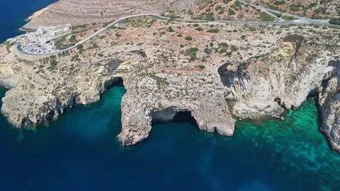 Sea arch and cliffs at Malta's Blue Grotto rising over turquoise water Stock Footage 337000868