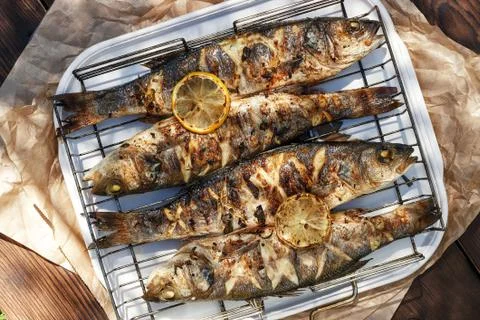 Sea Bass fish cooked on coals in a grill Stock Photos