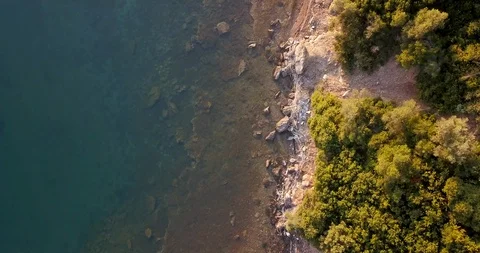 Sea bathing rocky coastline with sparse pine trees Stock Footage 107952093