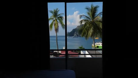 Sea bay view seen through window and half open curtains, dark empty bedroom Stock Footage 149852168