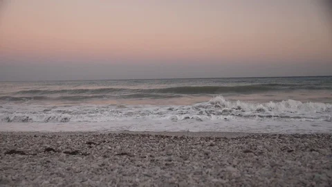 Sea beach from pebbles at sunset. Sea surf misty morning. Pre-dawn haze. Stock Footage 108998564