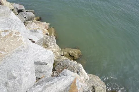 The sea is bordered by large breakwater rocks Fotos de archivo