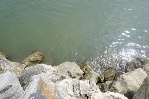 The sea is bordered by large breakwater rocks. sea and rock background Stock Photos