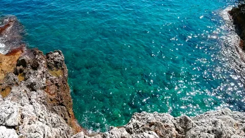 The sea breaks gently on the rocks of the Cap Martin in French Riviera Stock Footage 94758376