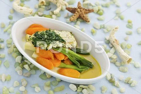 Sea bream fillet with herb pesto and a carrot and spring onion medley Stock Photos