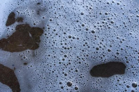 Sea Bubbles Washed Up On To Beach Stock Photos