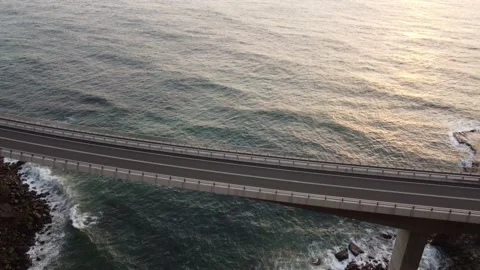 Sea cliff bridge with calming waves and Sunrise Stock Footage 143620665