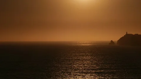 Sea cliffs and lighthouse at sunset Stock Footage 119069843