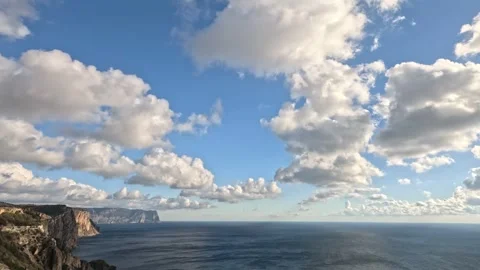 Sea, cliffs, clouds a beautiful seascape with dramatic cliffs meeting the calm Stock Footage 322609078