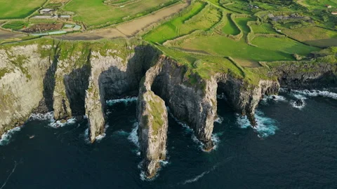 Sea cliffs with tall rock pillars and coastal erosion patterns at Azores Stock Footage 330483178