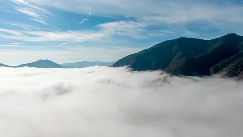Sea of clouds below a green mountain Stock Footage 127196596