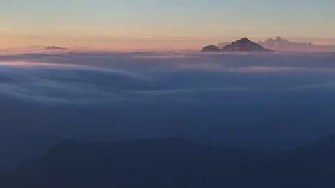 Sea of Clouds with Distant Snow-covered Peaks at Dawn Stock Footage 330759462