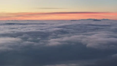 Sea of Clouds with Distant Snow-covered Peaks at Dawn Video stock 330759465