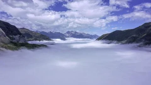 Sea of Clouds Flowing Through Mountain Valley Stock Photos