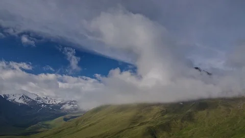 Sea of clouds on the slopes of alpine mountains with peaks 動画素材 78697639