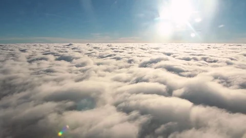 A sea of clouds under the sun, descending until under the clouds Stock Footage