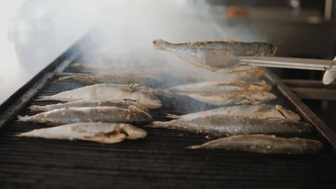 Sea fish is fried on a baking sheet in hotel or restaurant kitchen Video stock 111460520