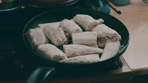 Sea fish rolled in flour is fried in a frying pan with oil. Stock Footage 163687894
