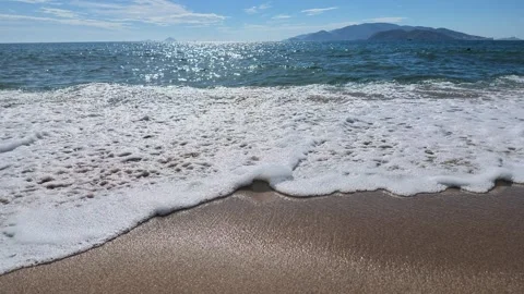 Sea foam and waves rolling on a sunny tropical sandy beach Stock Footage 344537301