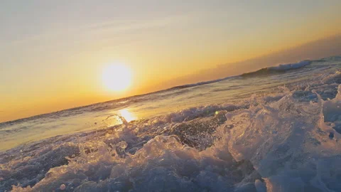 Sea Foam Rolling Across the Surface of the Ocean at Sunset With Golden Light Ref Stock Footage 337060572