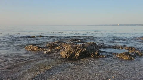 The sea gently lapping against some rocks Video stock 244384912