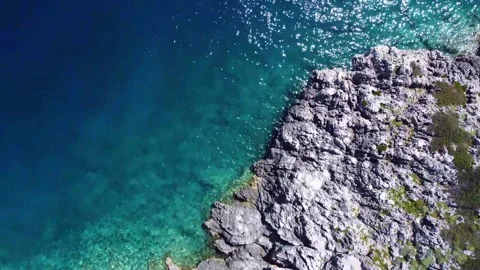 Sea gull passing over small uninhabited island with crystal clear blue sea Stock Footage 266685272