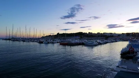 Sea harbour with boats and buildings in background - sunset Stock Footage