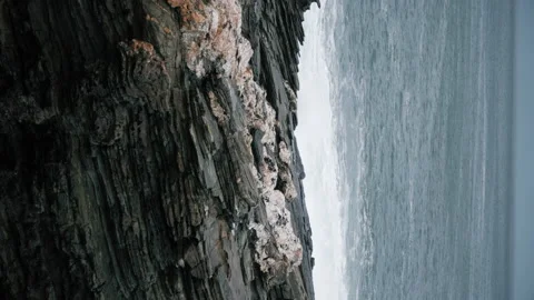 Sea hitting the cliffs on a grey winter day. 스톡 동영상 169748395