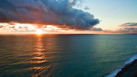 Sea landscape with dramatic sunset views and a large cloud. Stock Photos