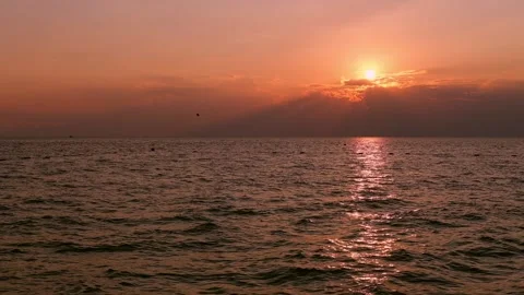 Sea with light waves at sunset. The setting sun is reflected in the water. Stock Footage