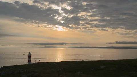 Sea with lighthouse and cloudy sky during sunset, Newfoundland, Canada Stock Footage 132397242