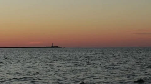Sea, lighthouse on mole at sunset Stock Footage 22007860